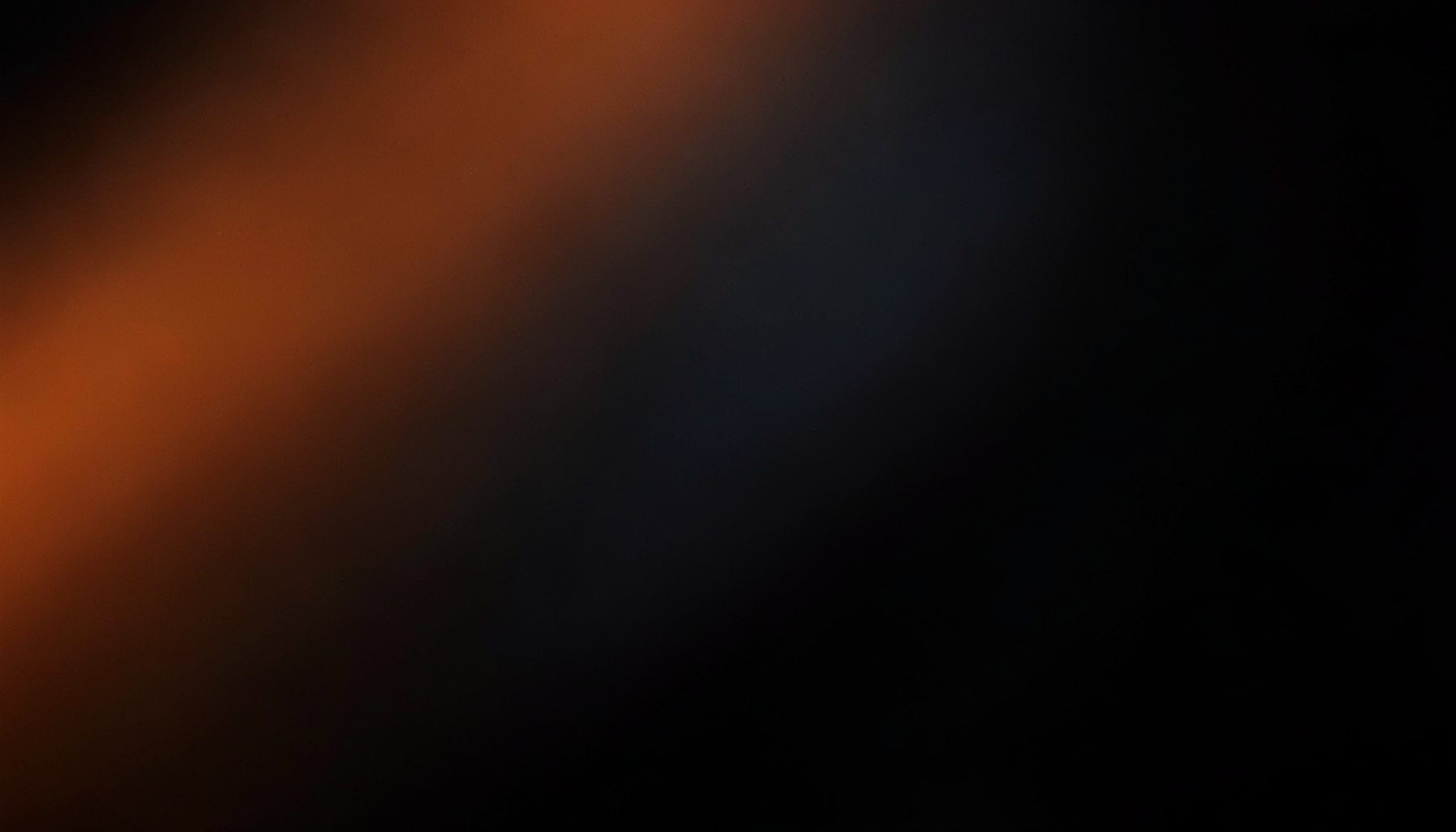 Dark abstract background with subtle orange and gray gradients suggesting depth and focus