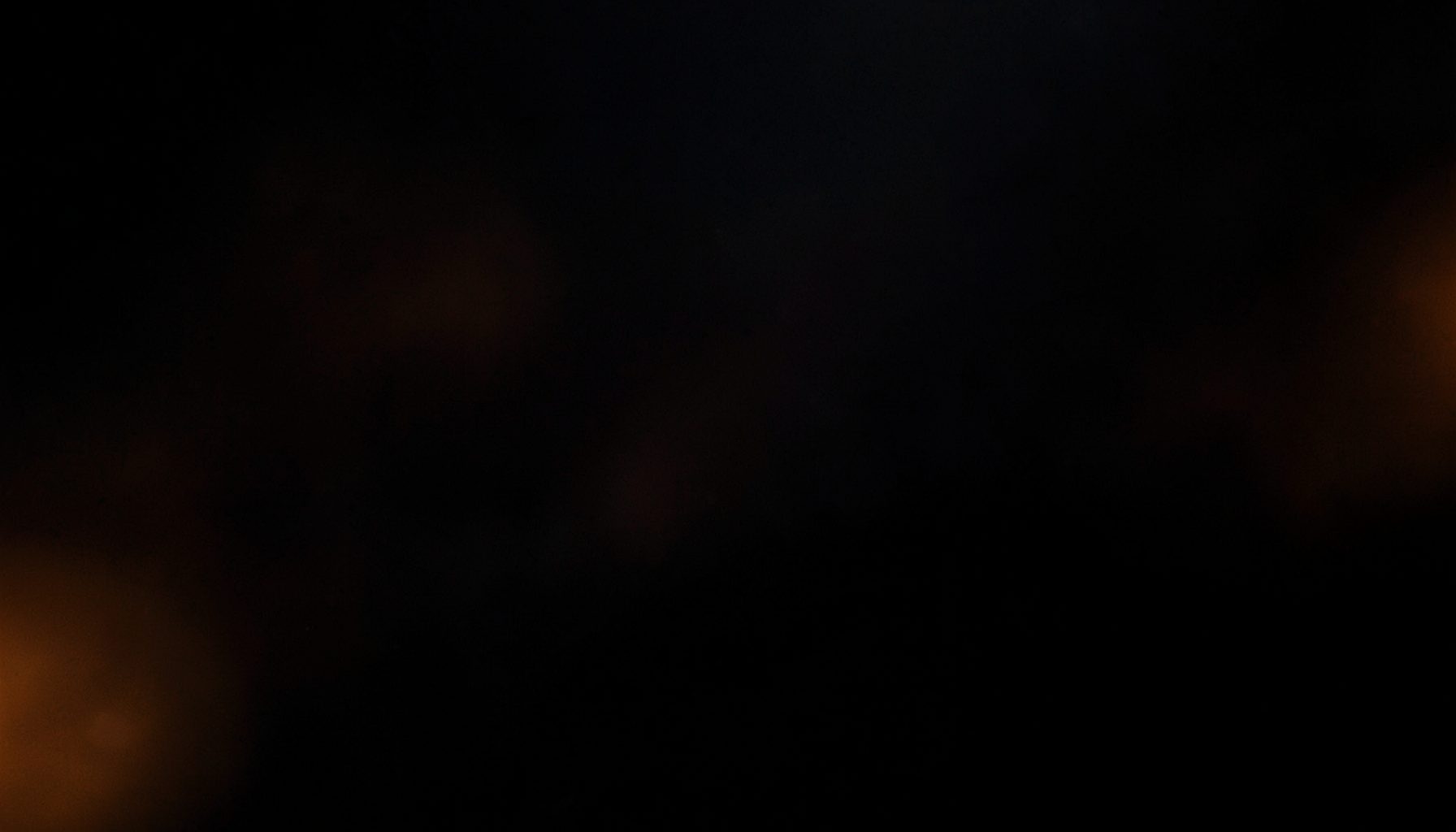 Dark atmospheric background with subtle warm orange light accents, conveying focus and clarity