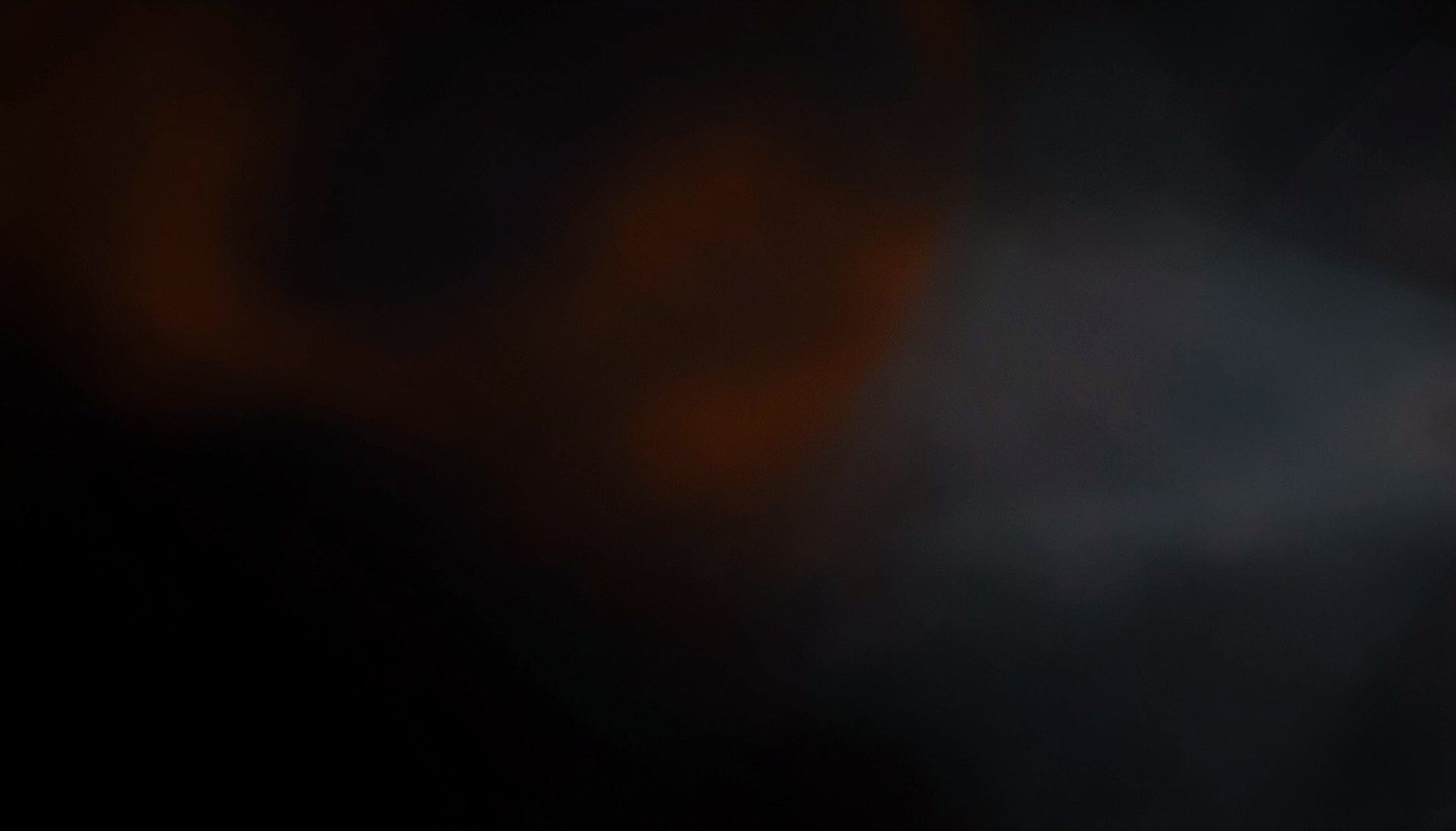 Dark abstract background with subtle orange and gray gradients, moody and tech-focused