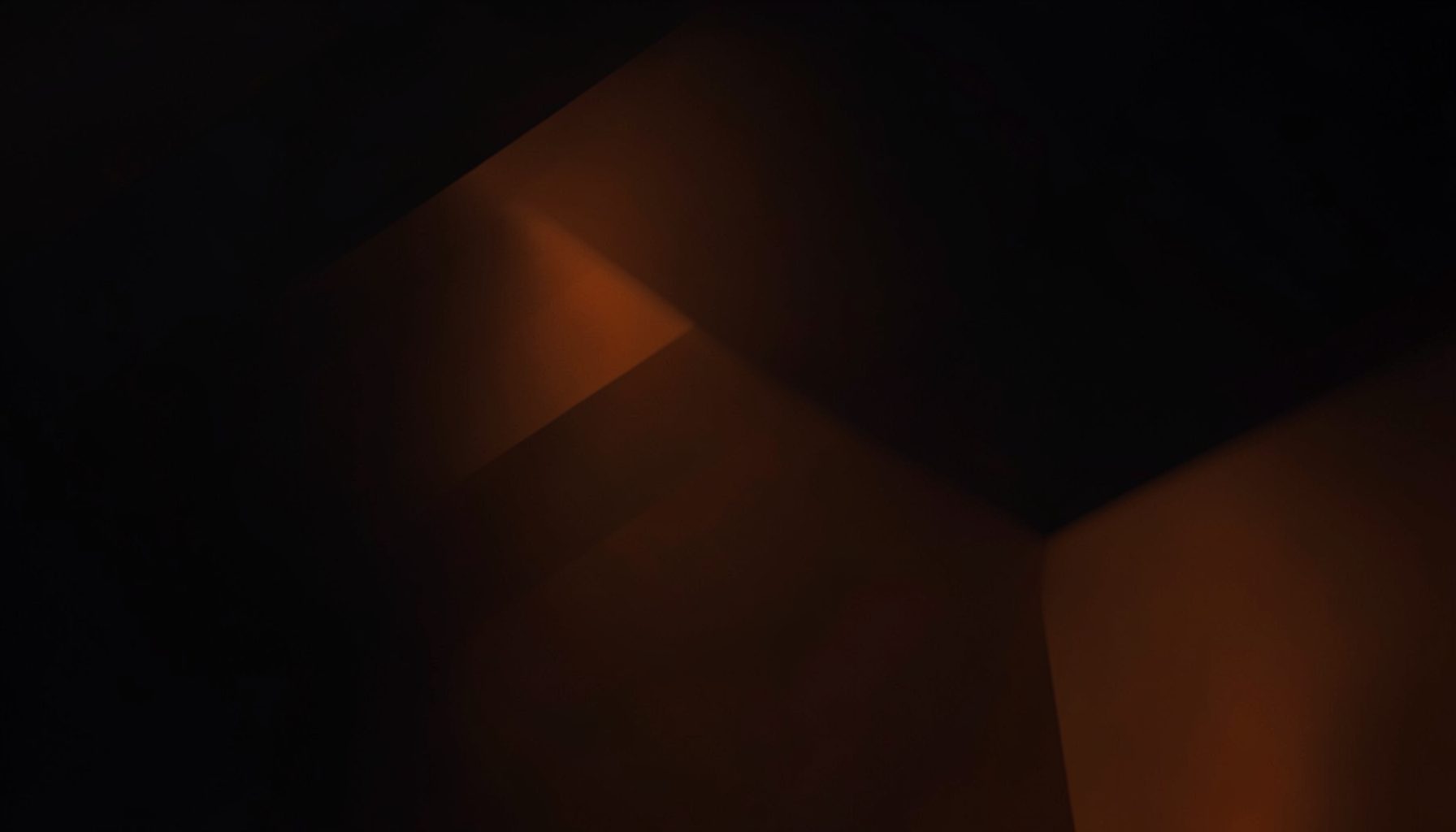 Dark abstract background with subtle warm orange tones and soft geometric shapes